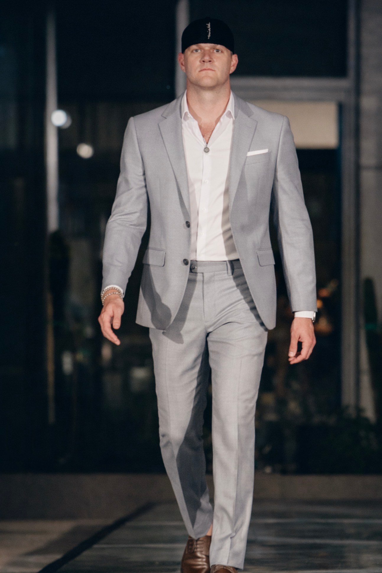 Male model wearing a tailored light gray suit by Jaq Lawrence, representing modern luxury menswear fashion